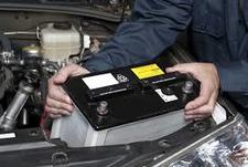 Man installing a new battery in a car. 
